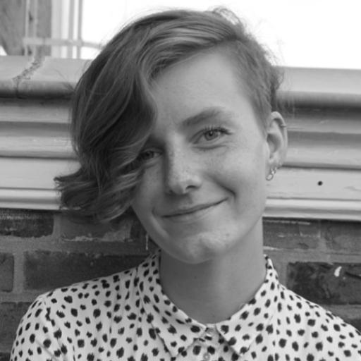 Carlijn Top - A white girl waring a dotted blouse. Her hair is long on the left side and her had is shave on the right side. 